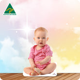 Baby in a pink outfit sitting on a wooden floor with a colorful background and Australian Made logo.
